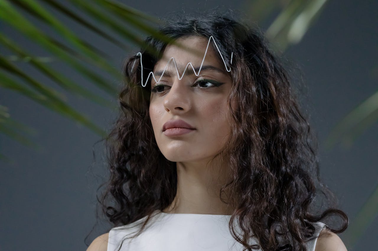 Studio portrait of a woman with curly hair and geometric line art, featuring a modern and artistic style.
